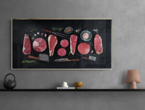 Tableau en plexiglas pour boucherie avec une variété de morceaux de viande et des accessoires de boucher.
